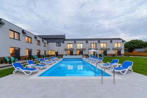 シフィノウイシチェにあるApartamenty Blisko Naturyの椅子と家のあるプール