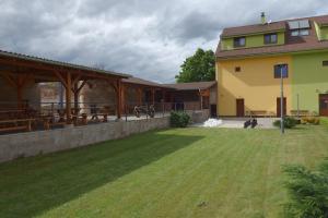 un gran patio con un edificio y un campo de césped en Penzion Bořikovský Dvůr, en Litovany