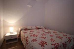 a bedroom with a bed and a table with a lamp at EFFE Apartment Golfo Aranci: Sole, Mare e Relax in Golfo Aranci