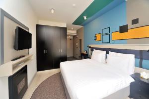 a bedroom with a bed and a flat screen tv at BoStay Hotel in Istanbul