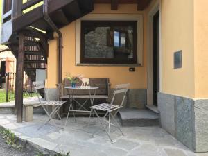 une terrasse avec une table et des chaises dans une maison dans l'établissement house of hearts - CIR10, à La Thuile