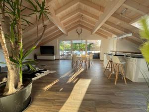 sala de estar con techos de madera, mesa y sillas en Lichtdurchflutete Wohnung mit großer Dachterrasse, en Bruckmühl