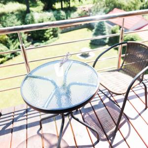 a glass table and chairs on a balcony at Golden park Apartments in Uman