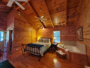 a bedroom with a bed and a tub in a log cabin at New River Trail Cabins in Galax