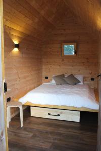 een slaapkamer met een bed in een houten hut bij Hiška-Glamping in Ajdovščina