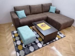 a living room with a brown couch and a coffee table at Apartman Bogdanović Sokobanja in Soko Banja