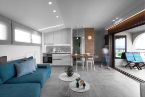 a living room with a blue couch and a kitchen at Pola's loft in Ierissos