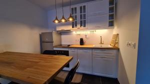 cocina con armarios blancos y mesa de madera en Appartement Plage Prado/Vélodrome, en Marsella