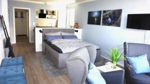 - une chambre avec un lit, un canapé et des chaises dans l'établissement Fördekoje, à Laboe