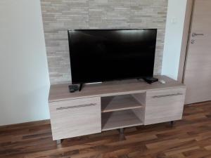 a flat screen tv on a wooden entertainment center at Adriatic Sunset House in Petrovac na Moru