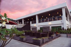 um edifício com um restaurante com pessoas sentadas na varanda em Timor Plaza Hotel & Apartments em Dili