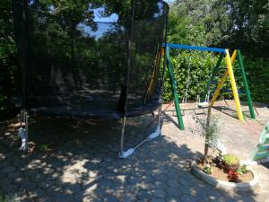 a playground with a swing set in a yard at Apartman Jurja in Ledenice