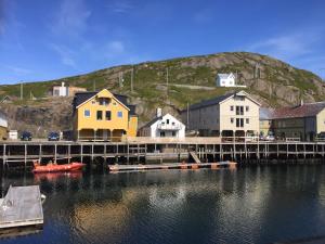 a group of houses and a dock on a body of water at NyksundRom - small holiday flat in Nyksund