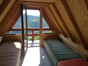 a room with two couches and a large window at Avlija Biberović in Sjenica