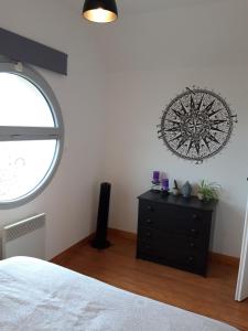 - une chambre avec une commode noire et une fenêtre dans l'établissement 192 rue de l’Impératrice, à Berck-sur-Mer