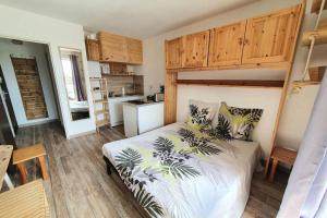 a bedroom with a bed with plants on it at Très charmant studio Plage du Penon in Seignosse