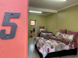 a room with two beds and a letter s on the wall at 4 on Sirius in Polokwane