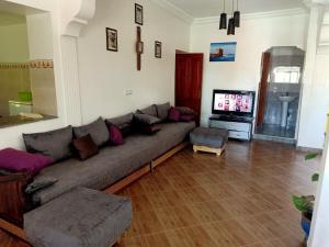 a living room with a couch and a flat screen tv at Jardin de rayane in Essaouira