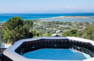 uma banheira de hidromassagem com vista para o oceano em Voula Villa Luxury em Lefkada