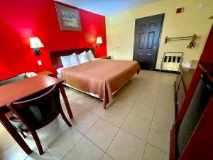 een hotelkamer met een bed, een tafel en een bureau bij Relax Inn McRae in McRae