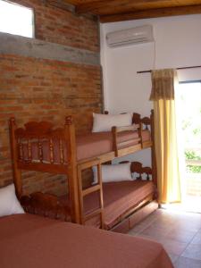 Habitación con 2 literas y pared de ladrillo. en La Casona en Gualeguaychú