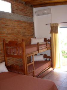 a room with two bunk beds and a brick wall at La Casona in Gualeguaychú