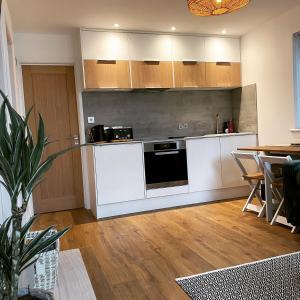 a kitchen with white cabinets and a table at Old Town Oasis in Eastbourne