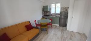 salon z kanapą i stołem oraz kuchnia w obiekcie Casetta Furiana w mieście Procida