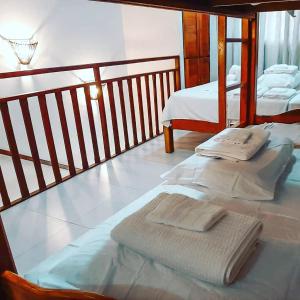 a bedroom with two beds with towels on them at Solar Água Pipa 125 in Pipa