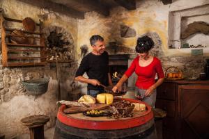 a man and a woman preparing food in a kitchen at MAXI SONCE, Odprte vasi in Prvačina +54 photos
