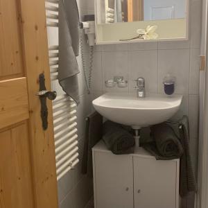 a bathroom with a white sink and a mirror at FeWo Gotschna Haus Bargis in Klosters Dorf