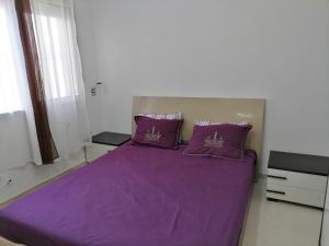 - une chambre avec un lit violet et 2 oreillers violets dans l'établissement Hergla_AFH_Beach, à Harqalah