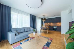 a living room with a blue couch and a table at Delta Luxury Apartment with terrace in Tartu