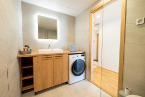 uma casa de banho com uma máquina de lavar roupa e um lavatório em Delta Luxury Apartment with terrace em Tartu