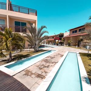 a villa with a swimming pool in front of a building at Solar Água Pipa 125 in Pipa