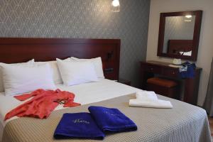 a hotel room with a bed with towels on it at Viaros Hotel Apartments in Tolo