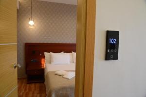 トロにあるViaros Hotel Apartmentsのベッドルーム1室(ベッド1台、壁掛け時計付)