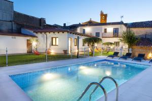 a swimming pool in the backyard of a house at Apartamentos Rurales Cielo de Monfragüe in Malpartida de Plasencia