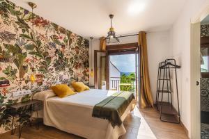 1 dormitorio con 1 cama con papel pintado con motivos florales en Apartamentos Rurales Cielo de Monfragüe en Malpartida de Plasencia