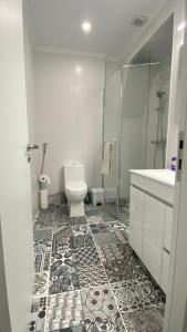 La salle de bains est pourvue de toilettes, d'une douche et d'un lavabo. dans l'établissement Coração da Vila, à Alcochete