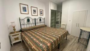 a bedroom with a bed with a comforter and a table at Coração da Vila in Alcochete