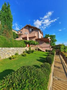ein Haus auf einem Hügel mit einem grünen Hof in der Unterkunft Nate Apartments in Ohrid
