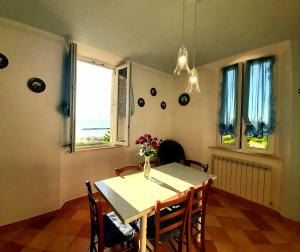 ein Esszimmer mit einem Tisch, Stühlen und Fenstern in der Unterkunft Bio Agriturismo Mare in Campagna in Campofilone