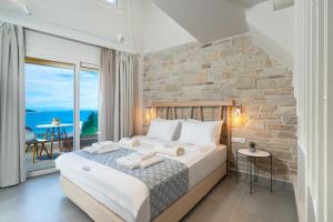 スカラ・ポタミアスにあるLithorama Boutique Suitesのレンガの壁、大きなベッド付きのベッドルーム1室 +37枚の写真