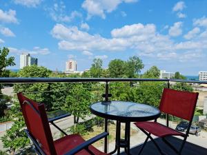 a patio table and two chairs on a balcony at Alfa Relax Apartments in Saturn