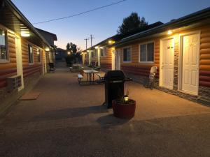 a row of wooden buildings with a patio at night at Alpine motel in Rocky Mountain House