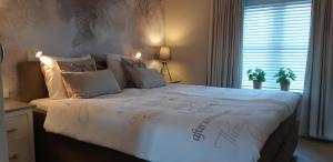 una camera da letto con un grande letto e un piumone bianco di Appartement Marigold a Zandvoort