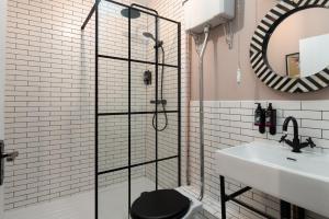 a bathroom with a glass shower with a toilet and a sink at Lonsdale house by Orenda-Luxe in Llandudno