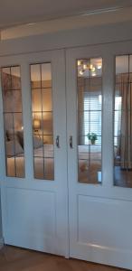 a white cabinet with glass doors in a room at Appartement Marigold in Zandvoort
