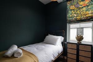 a bedroom with green walls and a bed with a window at Lonsdale house by Orenda-Luxe in Llandudno